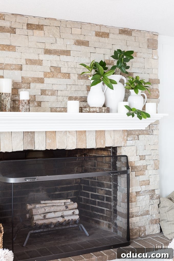 Cozy Winter Interiors: Cultivate Calm and Rejuvenation 8 Close-up of a stylish winter mantel featuring white pitchers, candles, and fresh evergreen branches