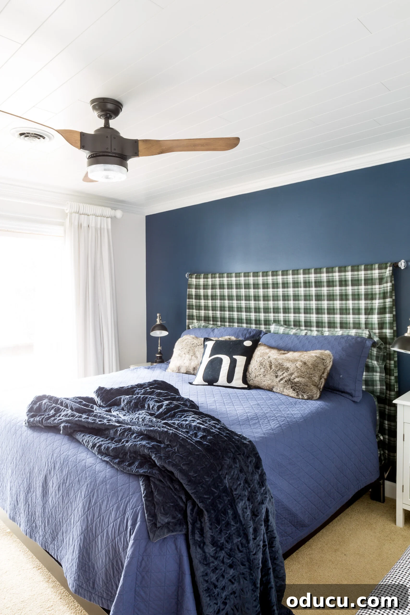 Easy DIY Headboard for Your Guest Space 12 Full view of a guest bedroom with a blue accent wall and a plaid sheet made into a king size headboard