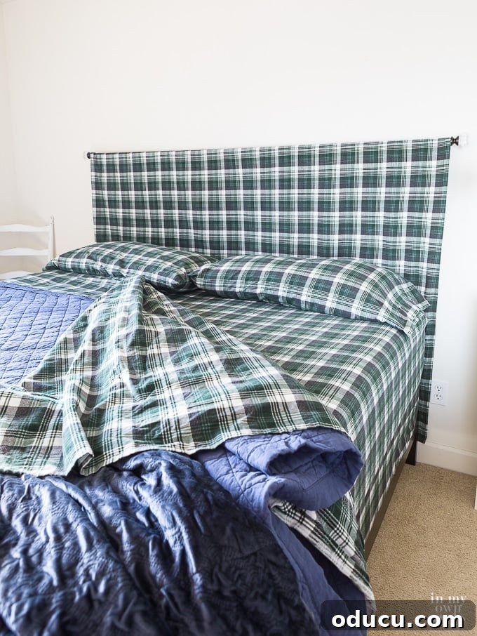 Easy DIY Headboard for Your Guest Space 4 Detailed view of a bed with a hidden box spring, covered by a fitted sheet, and a fabric headboard