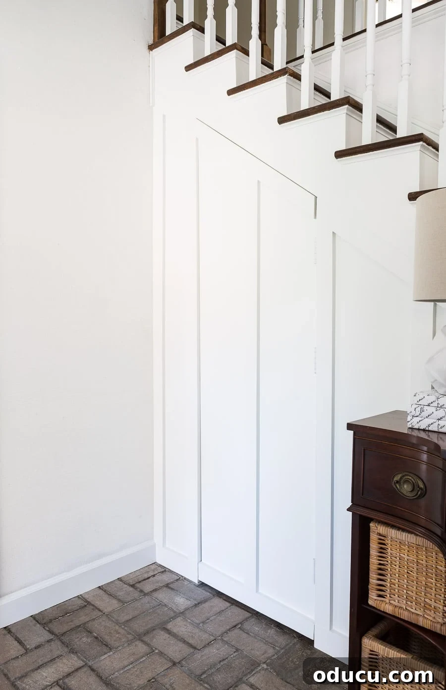 Transform Your Staircase into a Secret Storage Haven 11 Board and batten hidden door under a staircase, showing its integration into the wall design.