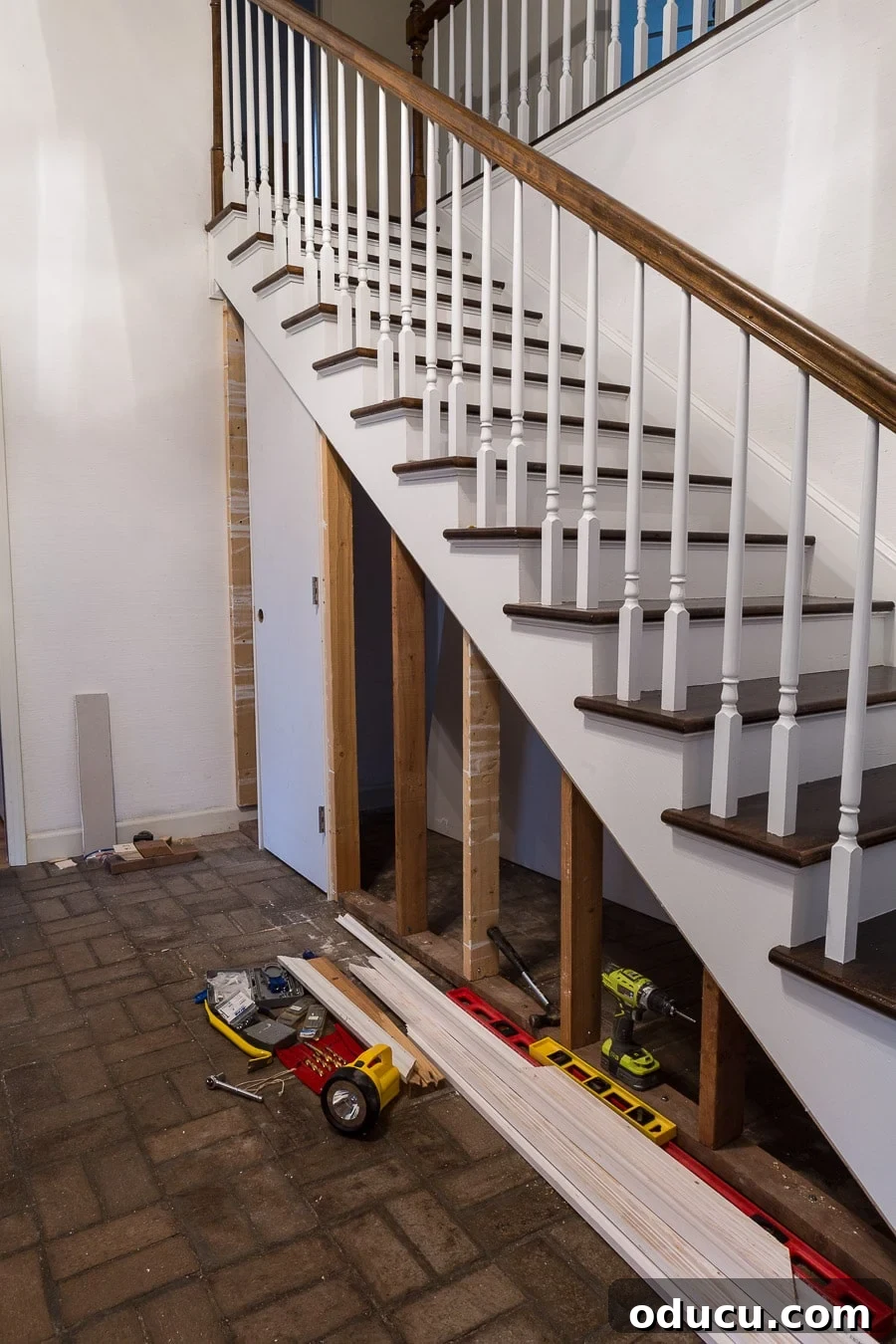 Transform Your Staircase into a Secret Storage Haven 16 Building a closet under a staircase with a hidden door, showing the doorknob hole filled with a wood plug.