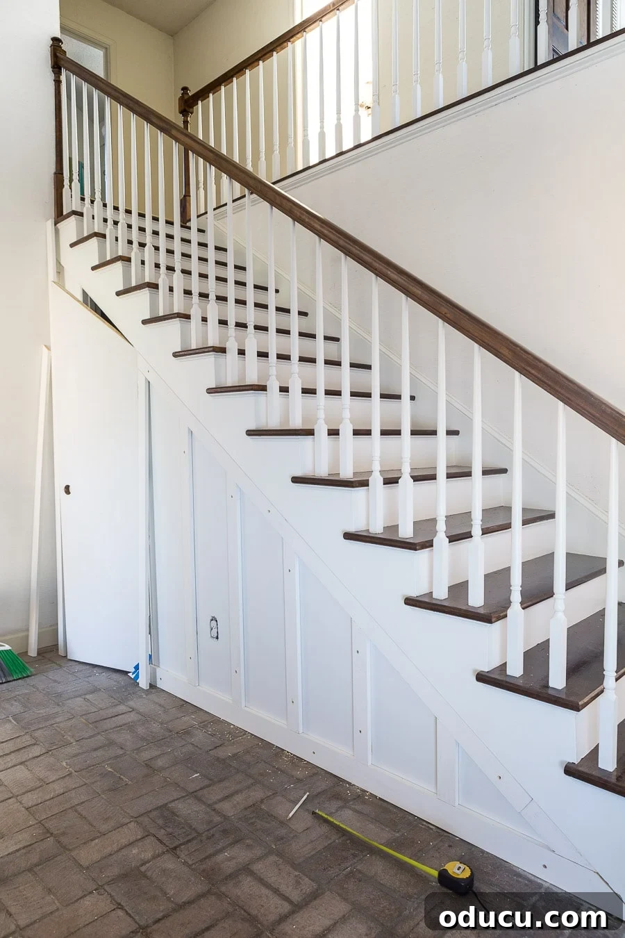 Transform Your Staircase into a Secret Storage Haven 20 Under a staircase closet ideas, showing the application of baseboard and vertical battens.