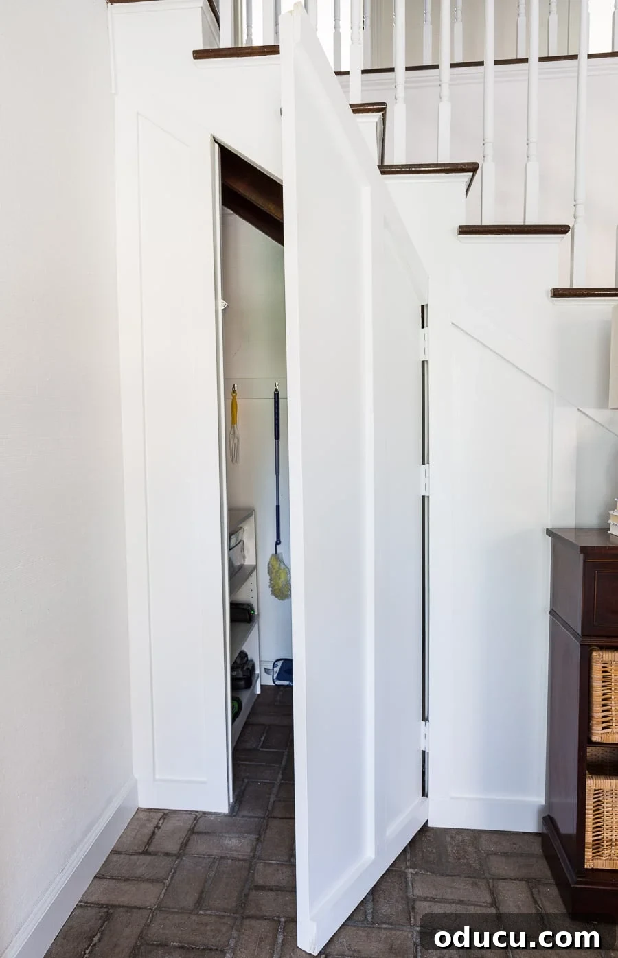 Transform Your Staircase into a Secret Storage Haven 30 Hidden door to DIY for an under a staircase closet, detailing the white hinges.