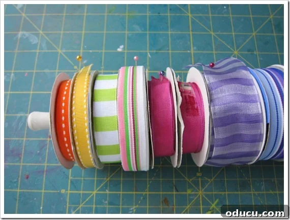 Conquer Ribbon Chaos: Genius Storage for Every Spool 24 Colorful ribbon rolls neatly arranged on a tension rod