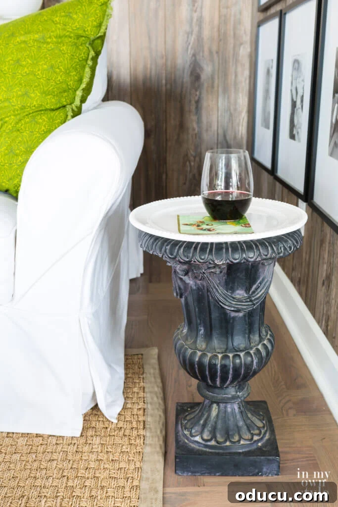 Transform an Old Urn into a Chic Side Table 7 Repurposed black garden urn functioning as a stylish end table, featuring a white cake plate as its secure surface.