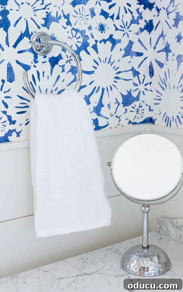 Elevate Your Bathroom With Towel Decor 2 A plain white bathroom hand towel hanging elegantly on a simple towel ring, showcasing its potential for decorative enhancement.