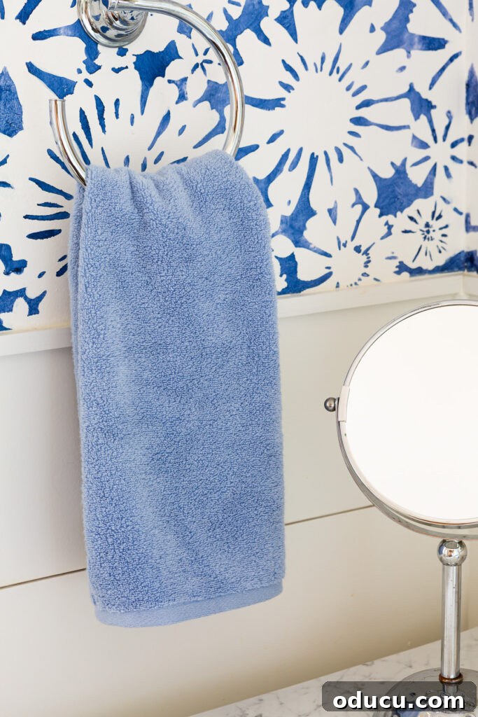 Elevate Your Bathroom With Towel Decor 4 A soothing plain blue bath towel hanging on a towel ring, illustrating how a simple base can be transformed with creative accents.