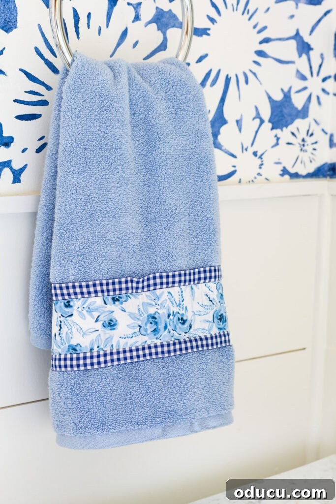 Elevate Your Bathroom With Towel Decor 5 A close-up shot of a soft blue towel beautifully enhanced with ribbon and fabric trim, perfectly coordinated with the bathroom decor to add visual interest.