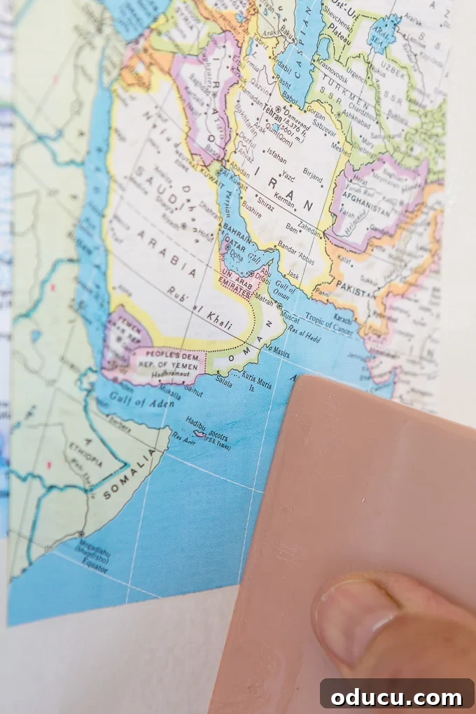 Globetrotting Laundry Room: DIY Map Wallpaper Project 26 DIY map wallpaper step by step tutorial that shows how to remove wrinkles that may appear when applying maps and or paper to walls