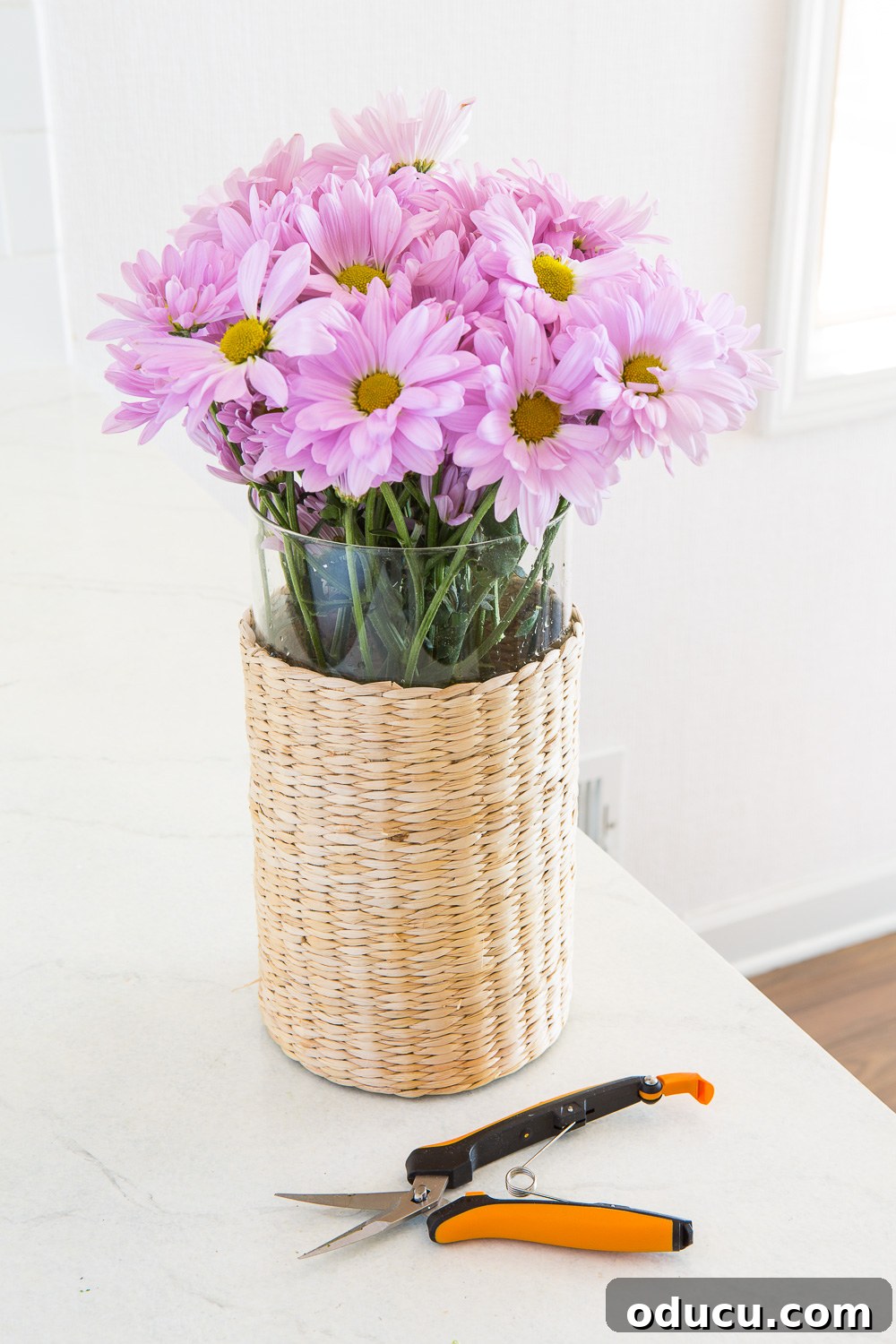 Beautiful Flower Arrangements Made Simple 4 A simple yet elegant flower arrangement in a glass and woven vase, showcasing the technique.