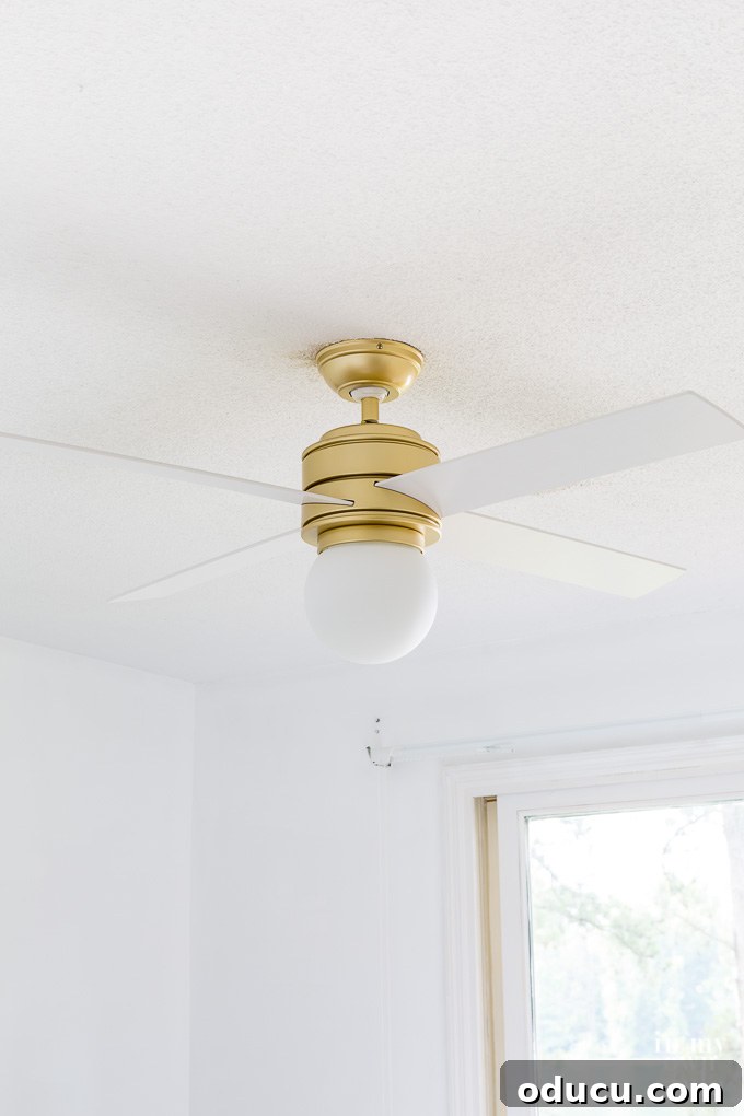 Guest Room Revamp in Motion 7 Close-up of the Hunter Hepburn gold ceiling fan with white blades, highlighting its sleek design
