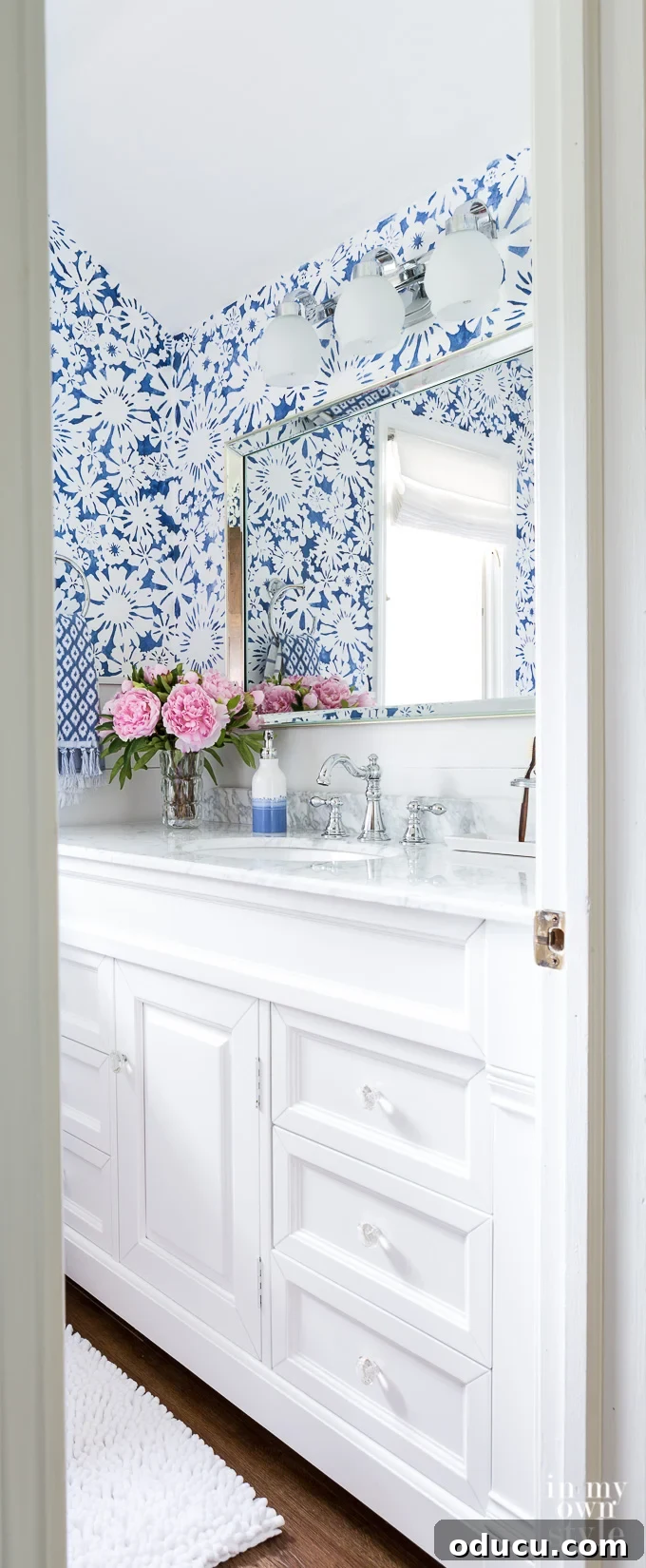 Bathroom decorating ideas for the DIY home decorator Peek into a blue and white small bathroom with pink flowers on vanity.