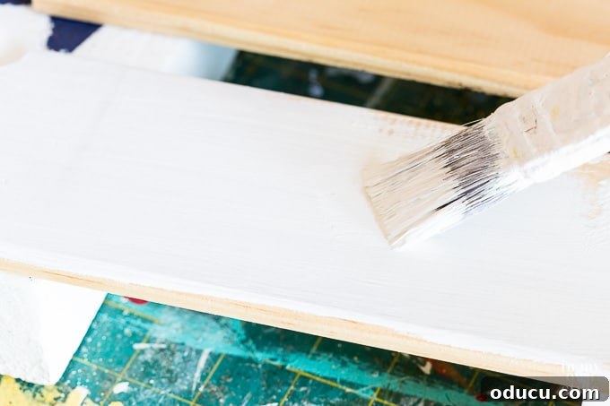 Chic French Inspired Door Plaques 12 Applying base coat of white chalk paint to wooden sign