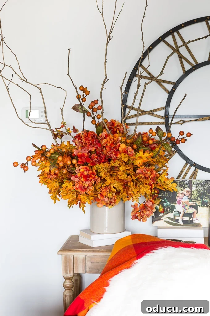 Effortless Autumn Centerpiece 11 Final stage of arranging faux hydrangeas, ensuring even distribution and secure placement in the foam, including stems falling below the crock
