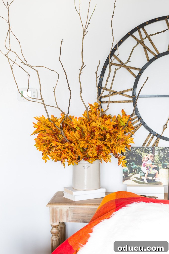Effortless Autumn Centerpiece 8 Additional faux fall leaf bouquets are added around the base of the arrangement, building volume and rich autumn color