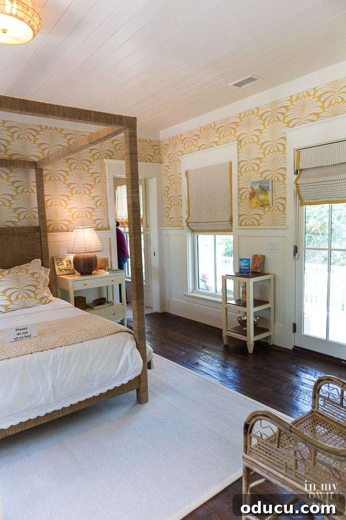 Design Dreams Unveiled at the Southern Living Idea House 35 Yellow and white bedroom decor with reclaimed flooring and subtle patterned wallpaper, offering a serene coastal feel
