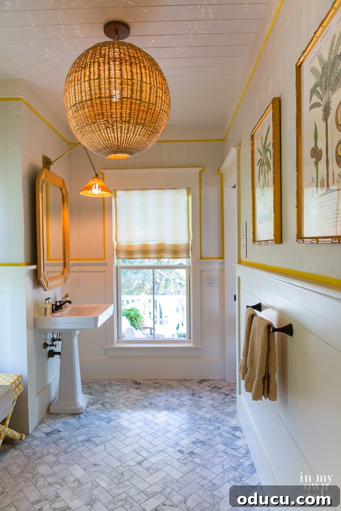 Design Dreams Unveiled at the Southern Living Idea House 38 Yellow and marble bath at the Southern Living Idea House, featuring wicker fixtures and Delta Faucet bronze hardware