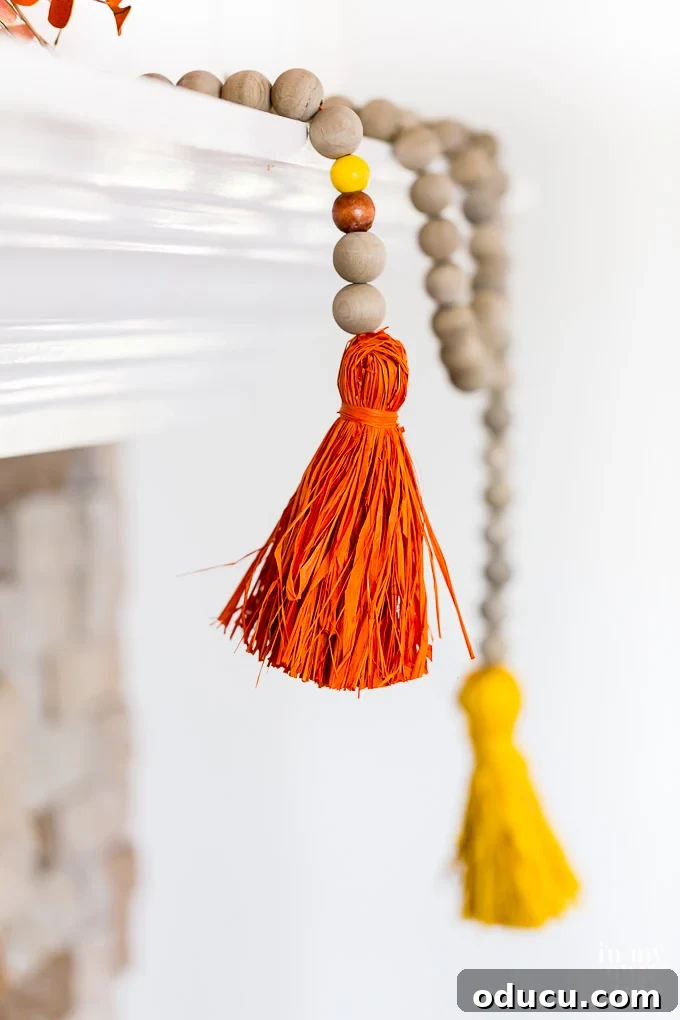 Craft Your Own Tassels: Elevate Your Home Decor 23 Driftwood stained wood bead garland for Fall with colorful raffia tassels.