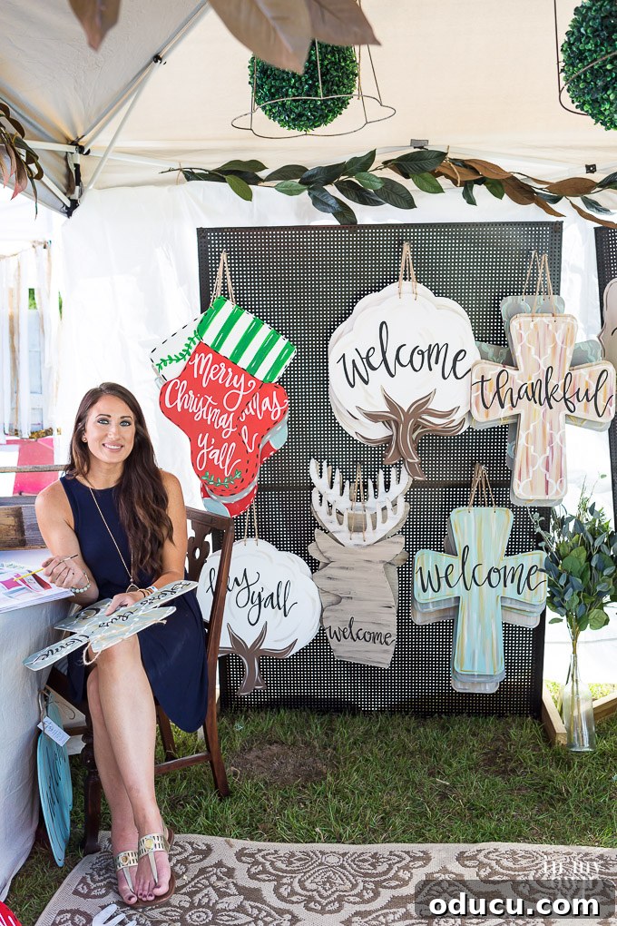 Rustic Riches: A French Flea Market Chronicle 10 Kristen Park, the owner of Southern Grace Gifts, stands next to her custom signs