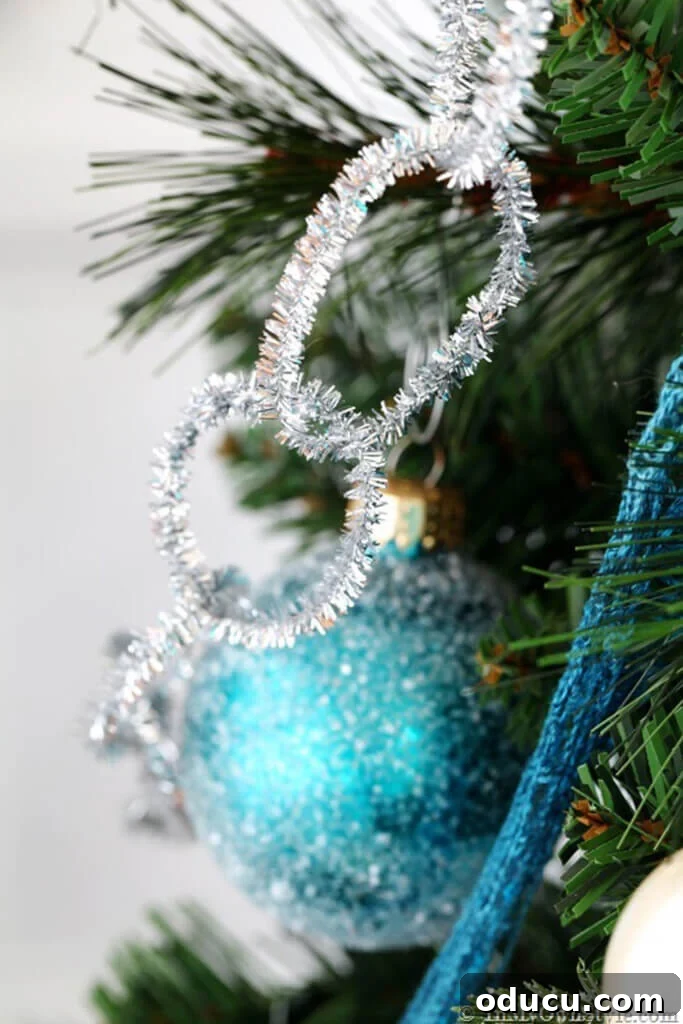 Sparkly Silver pipe cleaner garland and turquoise ornaments on Christmas tree.