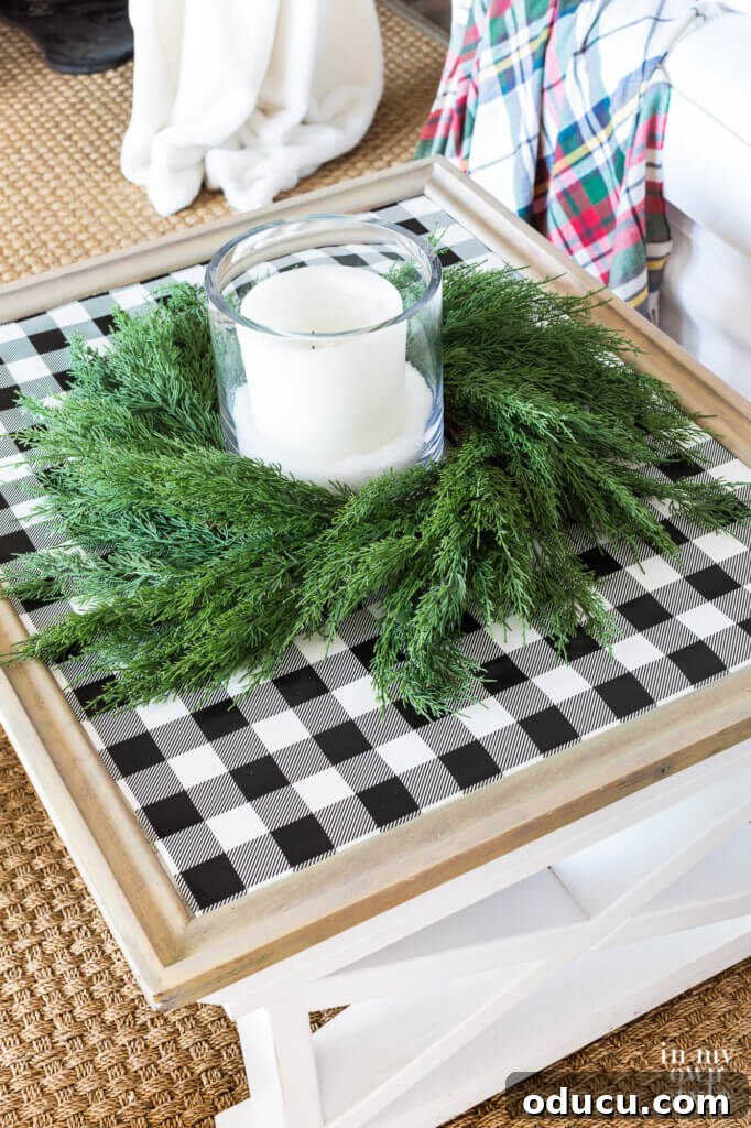 Farmhouse coffee table decorated for Christmas with black and white checked gift wrap on table top with cedar wreath and candle.