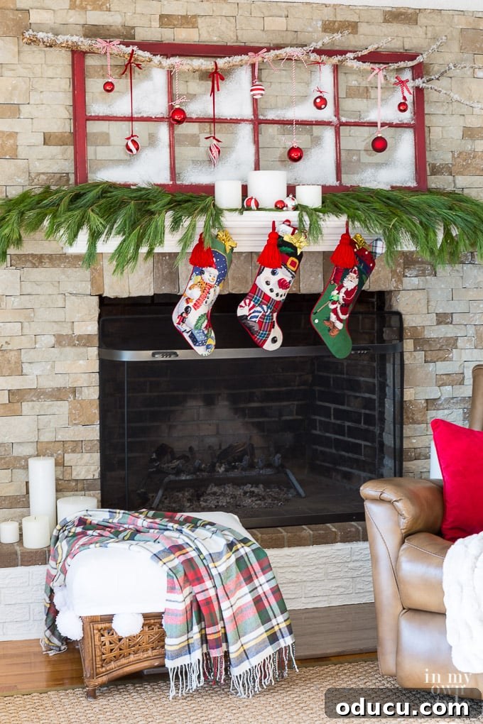 Frosted Window Mantelscape 2 Christmas mantel decorating idea that repurposes an old window sash and tree branch to create holiday spirit above the fireplace.