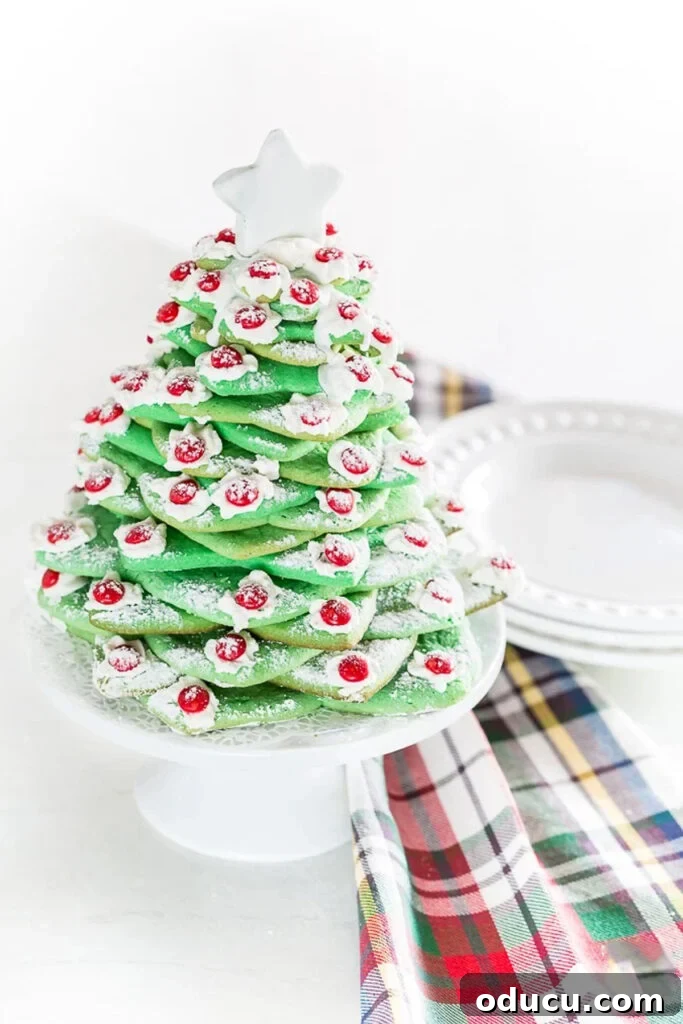Deck the Halls with Edible Cookie Trees 6 Christmas cookie tree made using various star-shaped cookie cutters, set next to a plaid dishtowel for a cozy holiday feel.