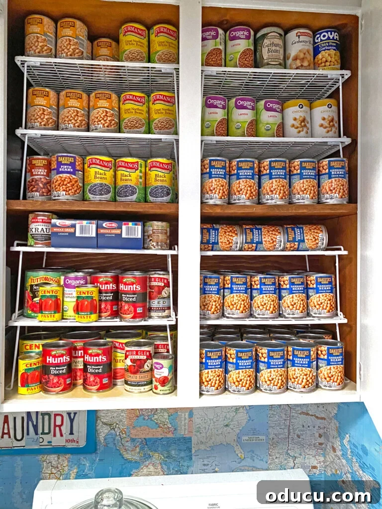 Pantry Closet Transformation 26 Organized canned storage in a laundry room cabinet using white wire racks for accessibility