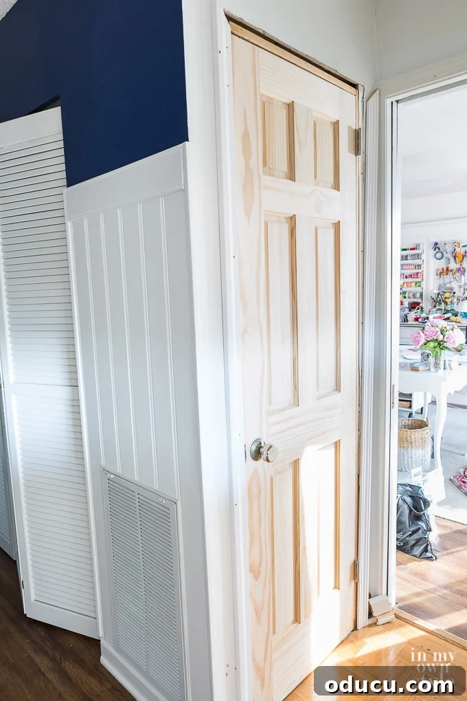Pantry Closet Transformation 7 New solid wood pantry door painted white, with a contrasting doorknob