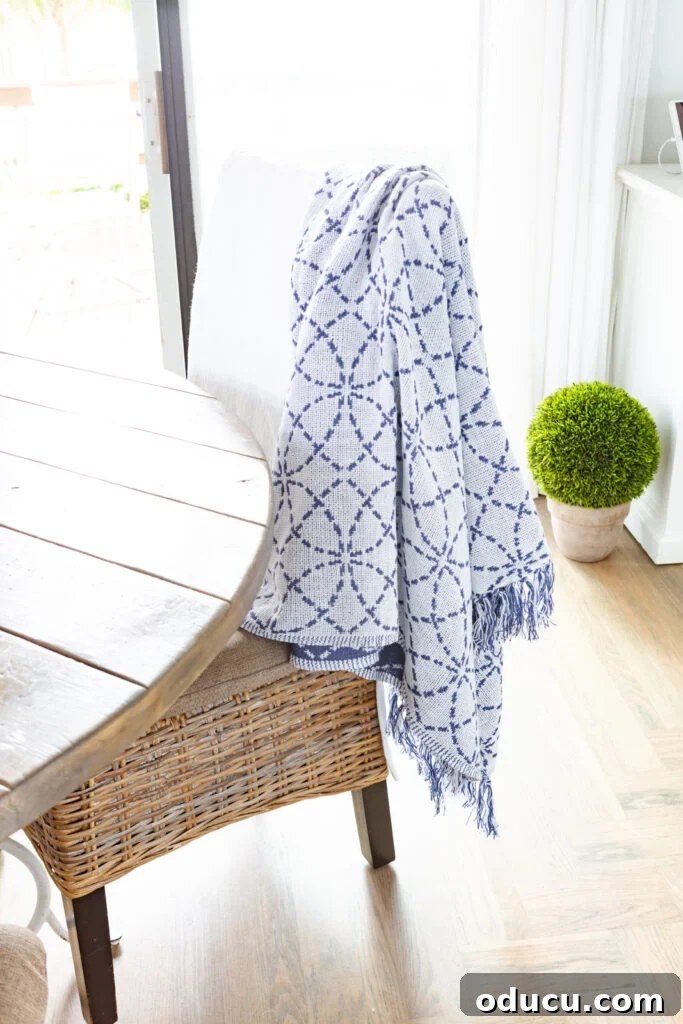Blue and white cotton throw blanket draped over a kitchen chair.