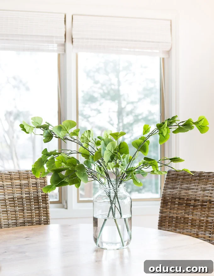 Mastering Faux Florals: Top 12 Decorating Secrets 8 Faux gingko stems in vase on water on kitchen table