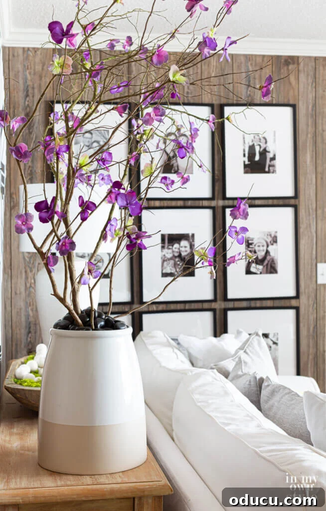 Mastering Faux Florals: Top 12 Decorating Secrets 9 Faux blooming branches in large planter behind a sofa