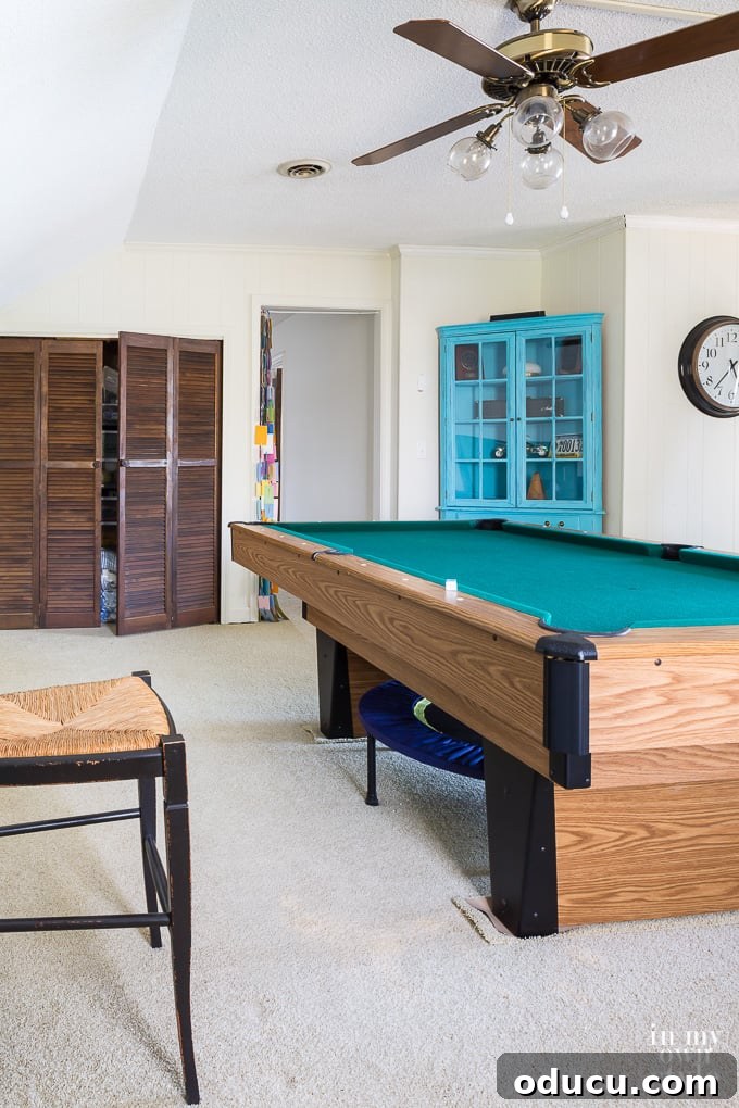 The Inaccessible Game Den 2 Before photo of a game room featuring a pool table and gym equipment, illustrating its current neglected state.