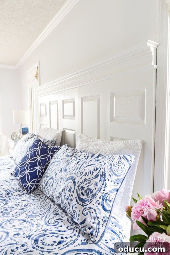 Stylish navy and white bedroom featuring a DIY headboard crafted from old doors
