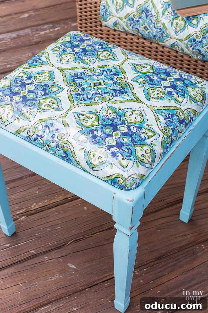 From Neglected Stool to Elegant Ottoman 7 Close up of the top of the newly painted turquoise and fabric-covered stool, showcasing the texture and color.