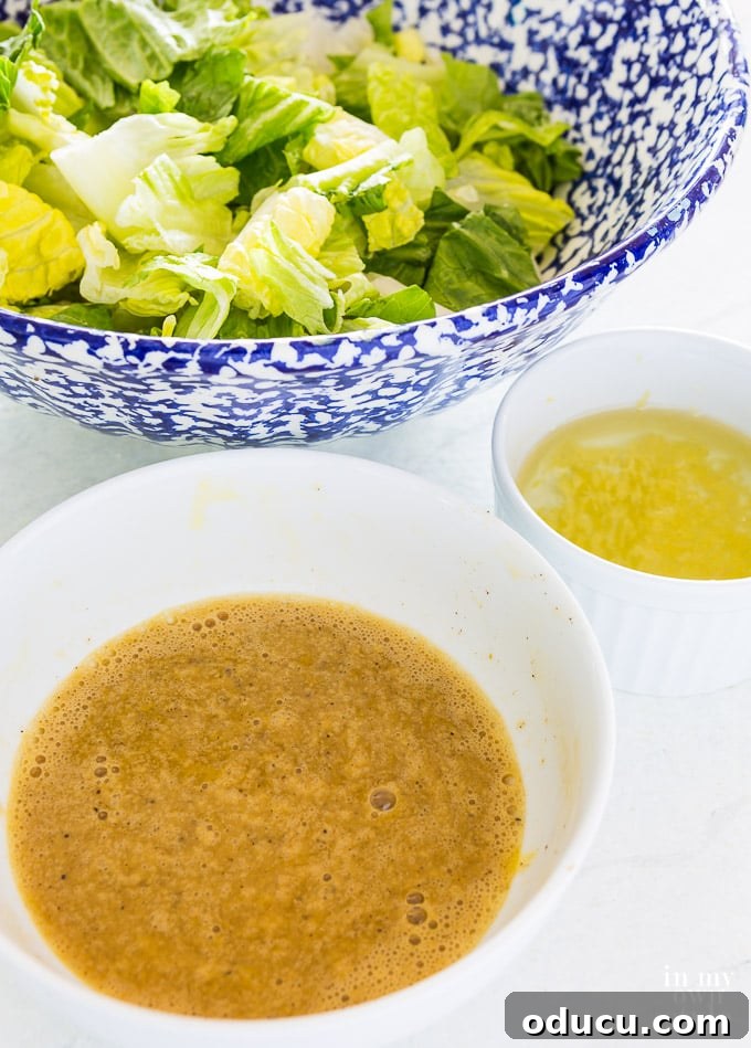 The Ultimate Anchovy-Free Caesar Salad 8 3 bowls - a blue and white one filled with lettuce, one with dressing and a small one with garlic oil.