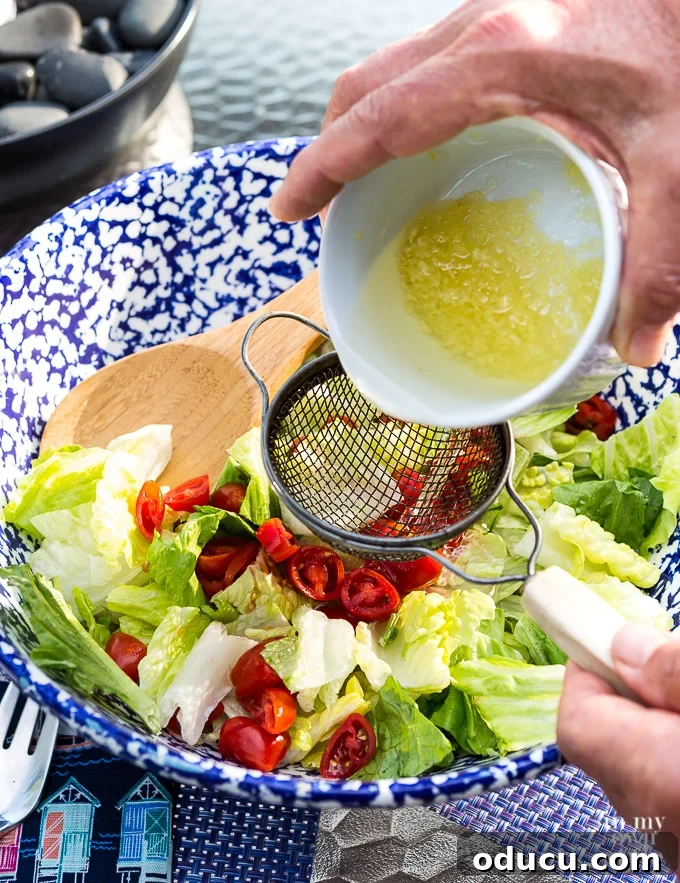 The Ultimate Anchovy-Free Caesar Salad 9 Pouring garlic oil over lettuce to make Caesar Salad.