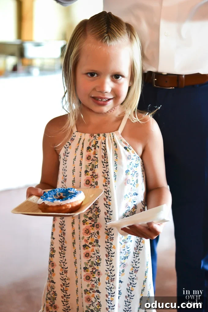 Build a Stunning Stacked Donut Wedding Centerpiece 3 Little girl eating from a donut wedding cake at a wedding