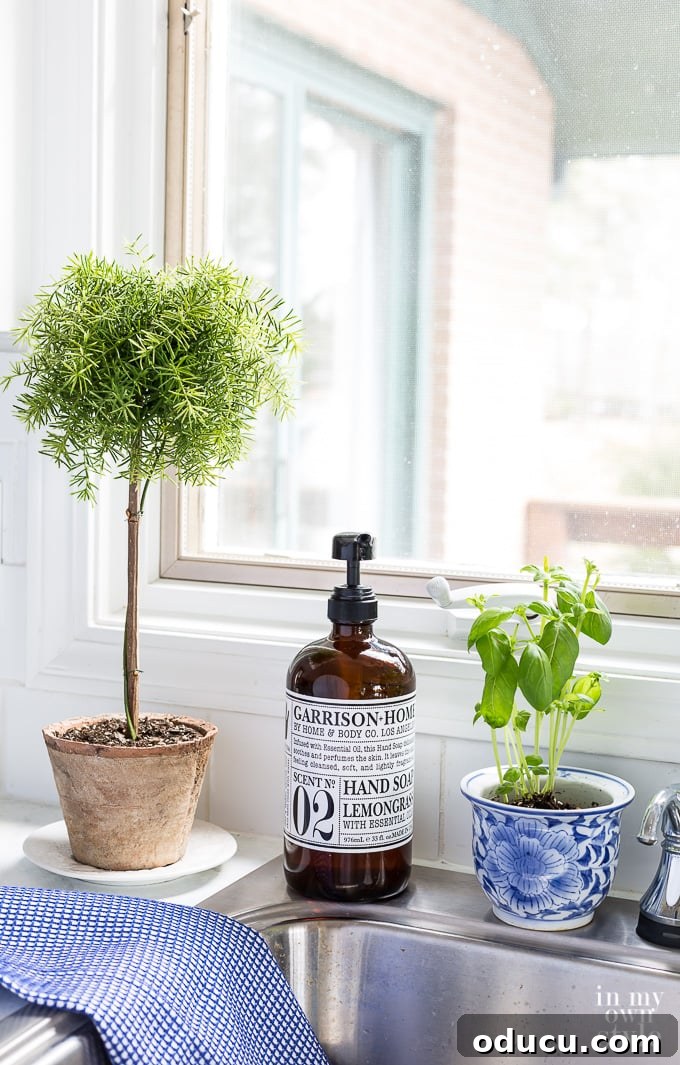 Craft Your Own Lifelike Topiary 2 Faux topiary decorating a modern kitchen counter with white cabinets and natural wood accents.