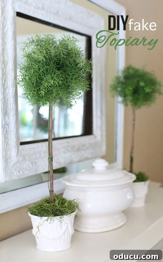 How to make a fake topiary that looks real. Two long-lasting DIY faux topiary trees displayed on a sideboard, reflecting in a mirror.