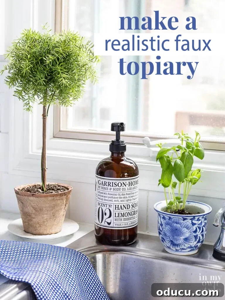 How to make a fake topiary tree that looks real using items from the craft store. #topiary #topiaries #DIYflorals #moderntopiary #farmhouse #farmhousedecor Large image of a finished DIY faux topiary on a kitchen counter, with text overlay 'Make a Realistic Faux Topiary'.