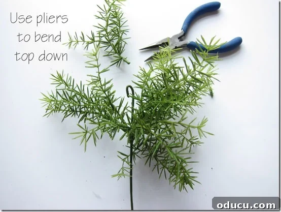 Craft Your Own Lifelike Topiary 8 Bending the wire at the top of an artificial greenery stem to create a stop.
