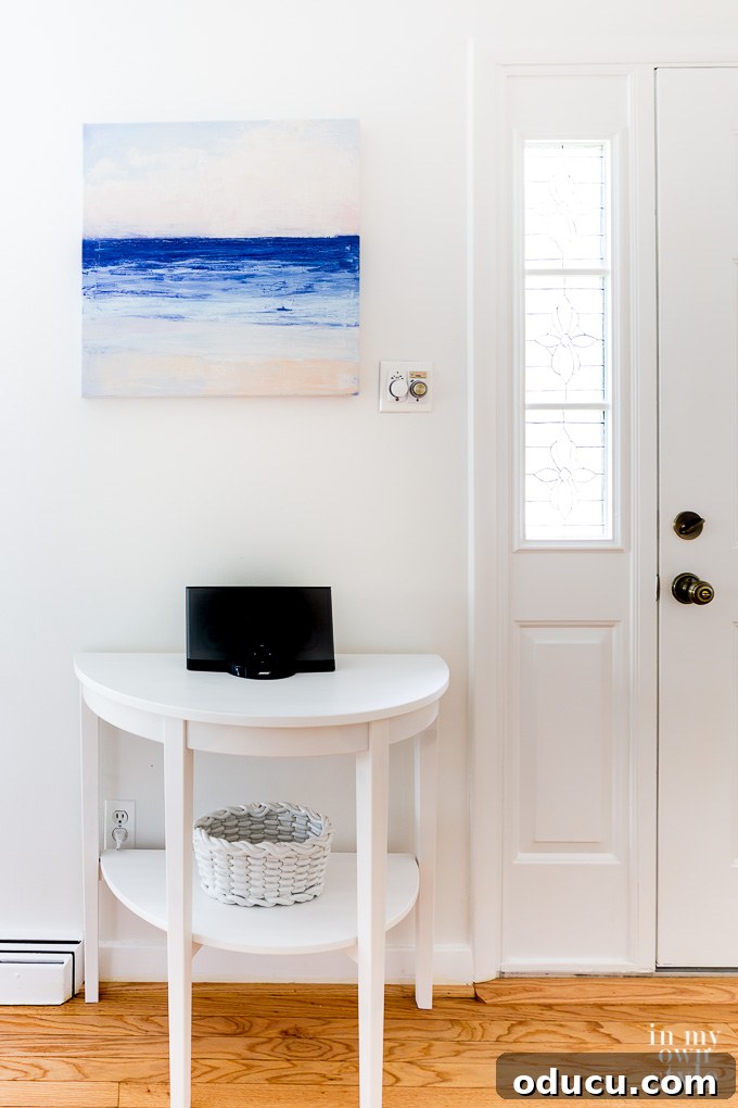 A small, elegantly decorated foyer with a mirror and subtle decor, showing the potential for transforming even compact spaces.