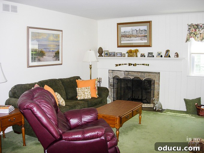 A second view of the cluttered living room before its decorating makeover, showing older furnishings.