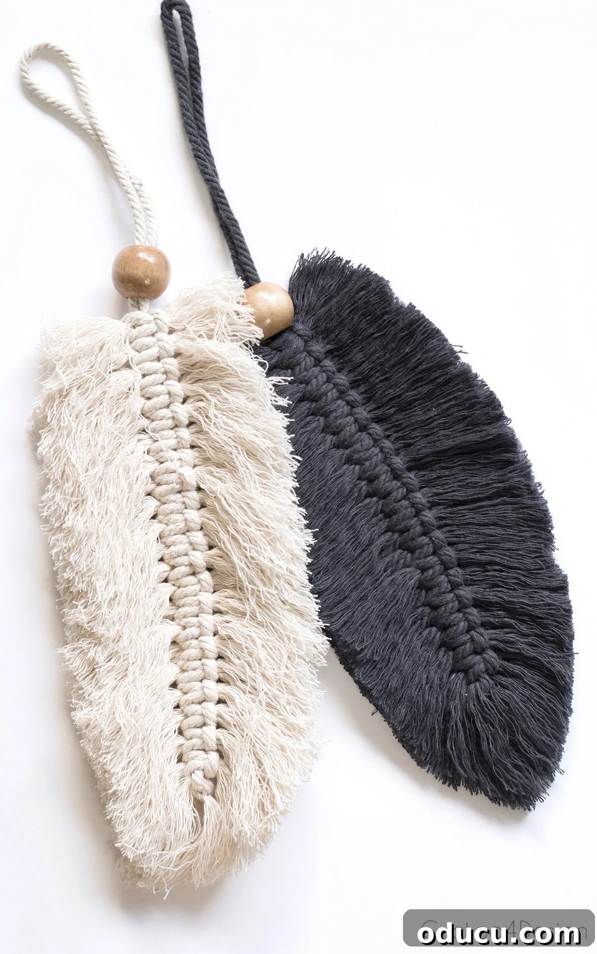Style Quest 2 Two macrame feather purse charms hanging, showcasing intricate knotwork and natural textures.