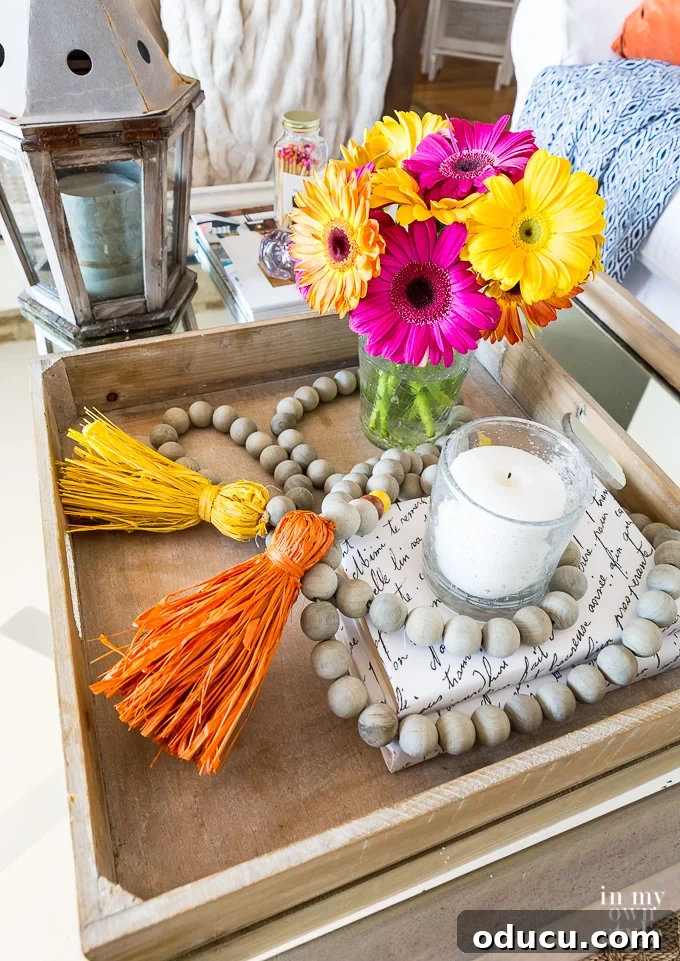 DIY Wooden Bead and Tassel Garland: Autumn Table Decor Inspiration A beautifully decorated table tray showcasing a DIY wooden bead and tassel garland, styled for autumn.
