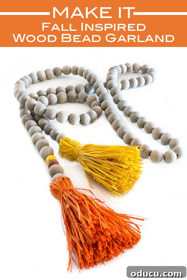 DIY Autumn Wood Bead Garland with Raffia Tassels for Fall Decor A close-up of a DIY autumn-inspired wood bead garland featuring orange and yellow raffia tassels, beautifully styled for fall decor.