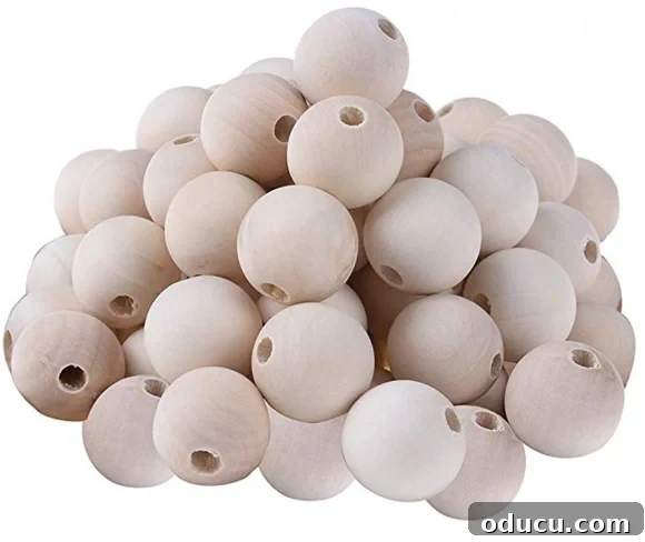 Natural Wood Beads: The Foundation for Your DIY Garland A bag of natural, unfinished 25mm wood beads, ready to be stained for a decorative wooden bead garland project.