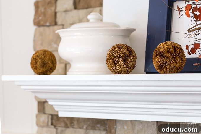 3 rustic balls lined up on autumn inspired mantel 3 rustic balls lined up on autumn inspired mantel