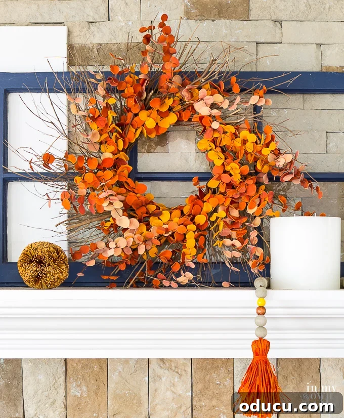 How to decorate a mantel using a fall wreath. An orange paper circle wreath on a navy blue window sash.